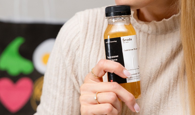 Kobieta trzyma napój rozgrzewający w butelce 